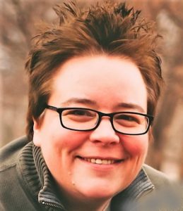 Julie Taylor picture. Short brown hair wearing glasses. Smiling.